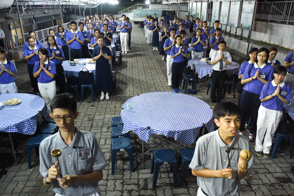 在营队中，两位学长带领学员们体验念佛入斋堂的“过堂”仪式，学习礼仪之美也呈现人文气质。(摄 / 陈清华)