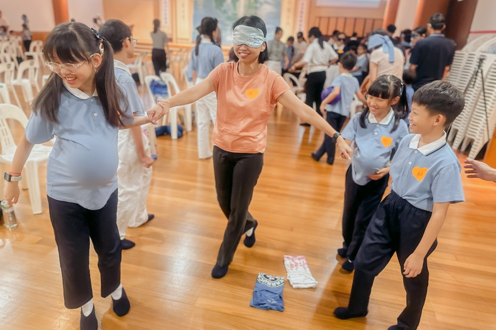 接下来的亲子互动环节，更考验彼此之间的信任，由孩子引领蒙上双眼的父母，在双方不靠言语只运用触感和手势的情况下，合作进行各项任务挑战。(摄/ 许金龙)